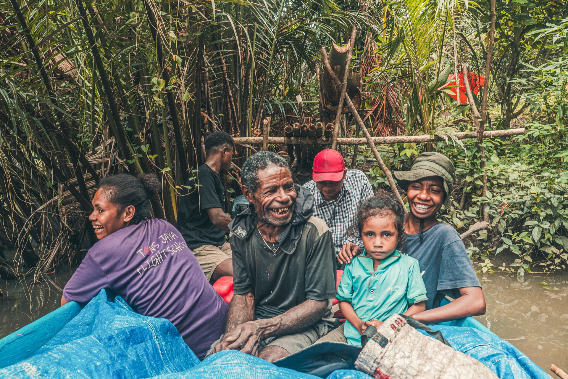 West Papua community members in a boat on the river